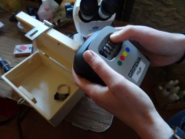 2 Hände die einen Zahlencode in ein Gerät eingeben