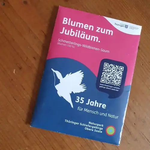Ein Saatguttütchen in Blau roten Farben. Die Aufschrift lautet: Blumen zum Jubiläum. 35 Jahre Naturpark Thüringer Schiefergebirge/Obere Saale für Mensch und Natur.